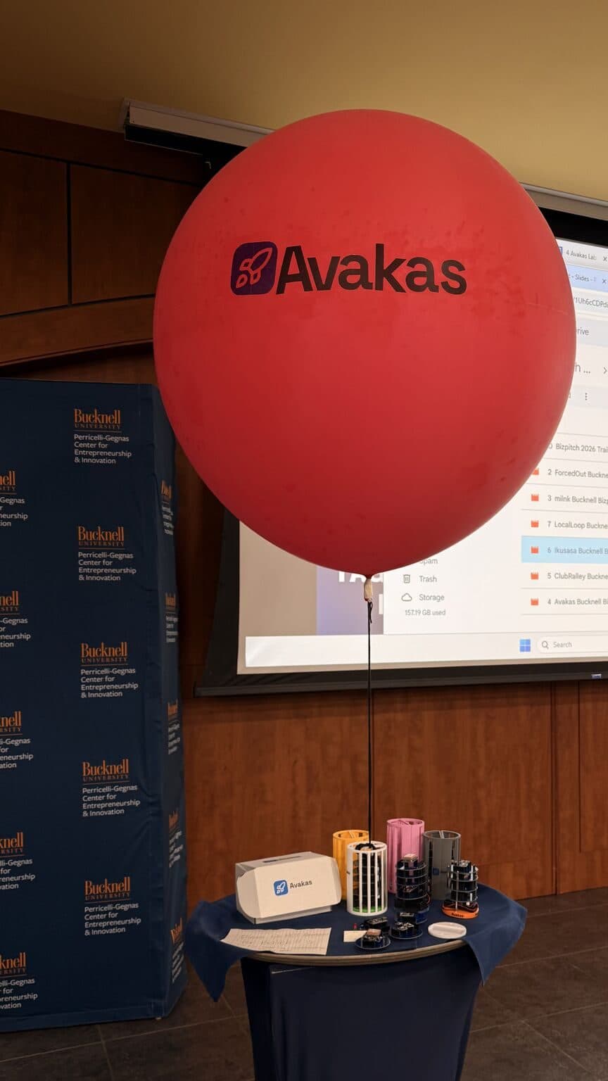 The launch balloon tethered above a table of Avakas CanSat kits and their carry case.